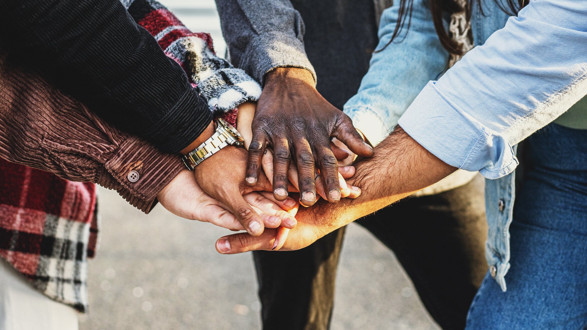 Diversity and teamwork as a group of diverse people joining hands as a multiracial society and multicultural community